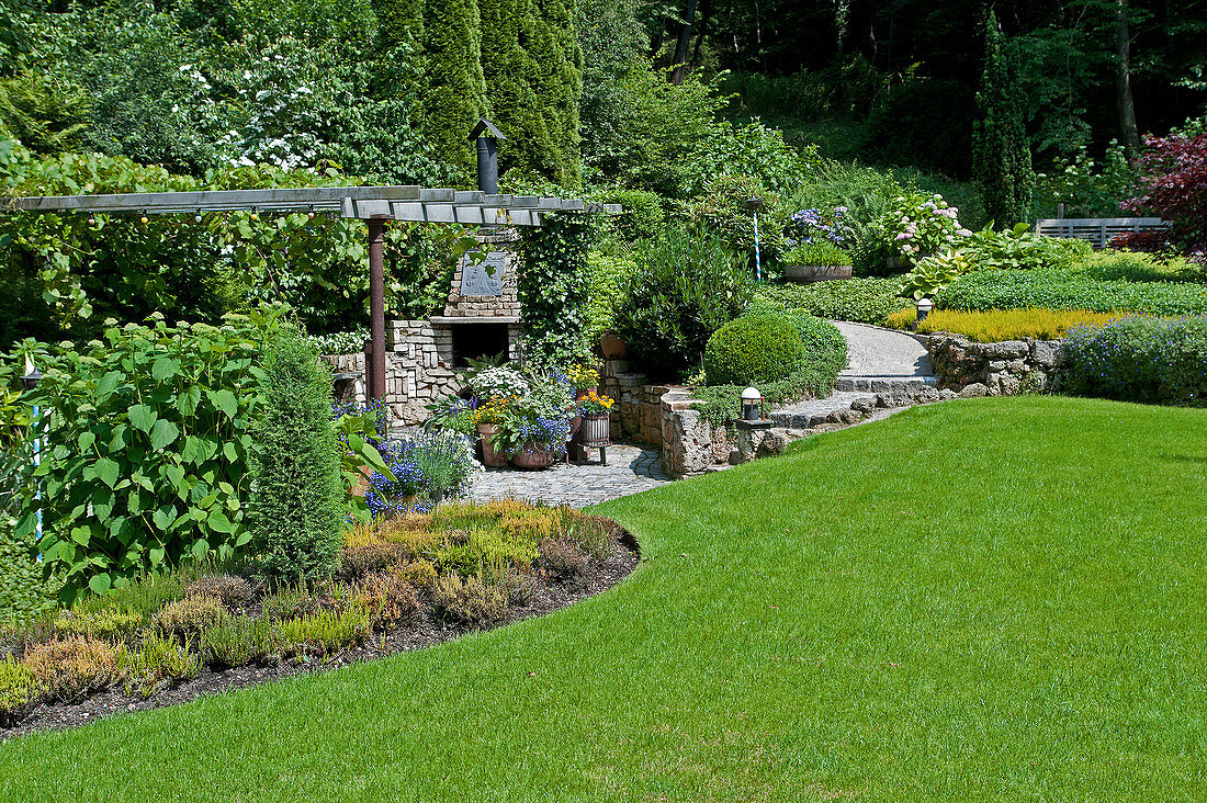 Pergola, flower beds and well-tended lawn in spacious garden