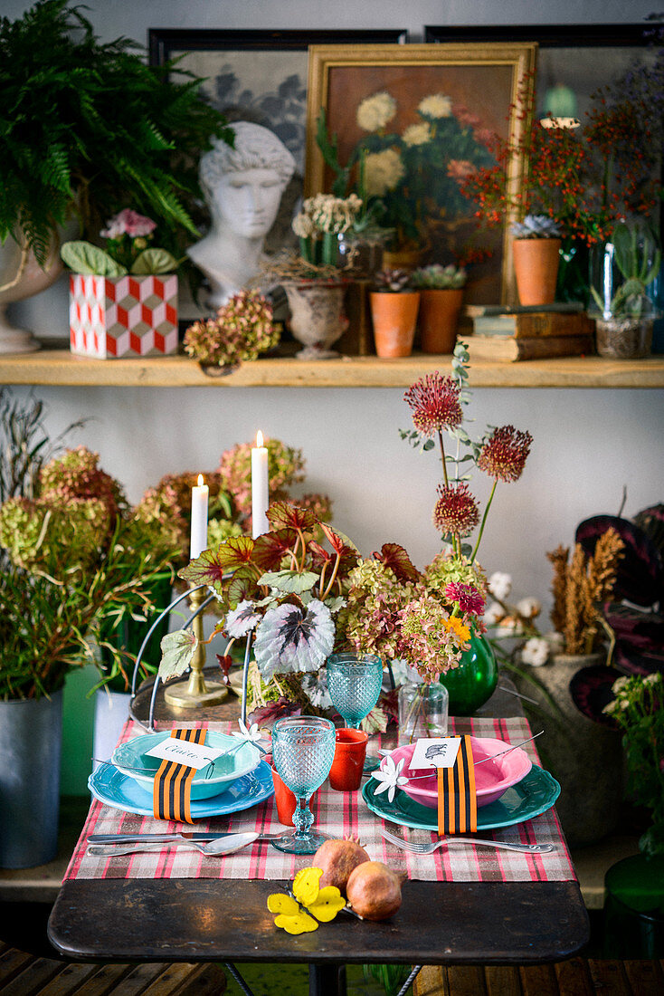 Mit verschiedenen Pflanzen und Blüten dekorierter Tisch für Zwei
