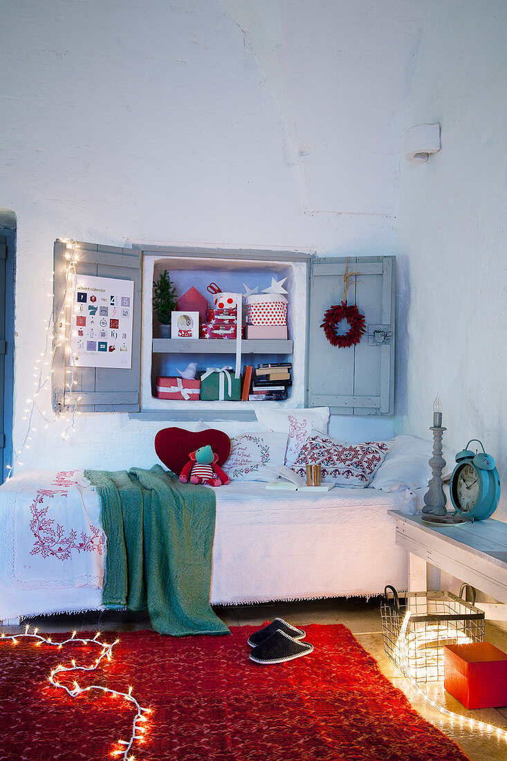 Nischenregal mit Fensterläden über Bett in weihnachtlich dekoriertem Kinderzimmer