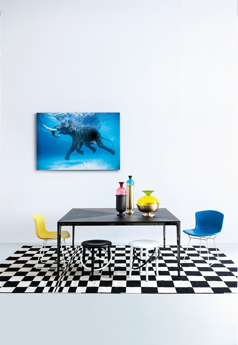 Black table with shell chairs and stools on black-and-white rug