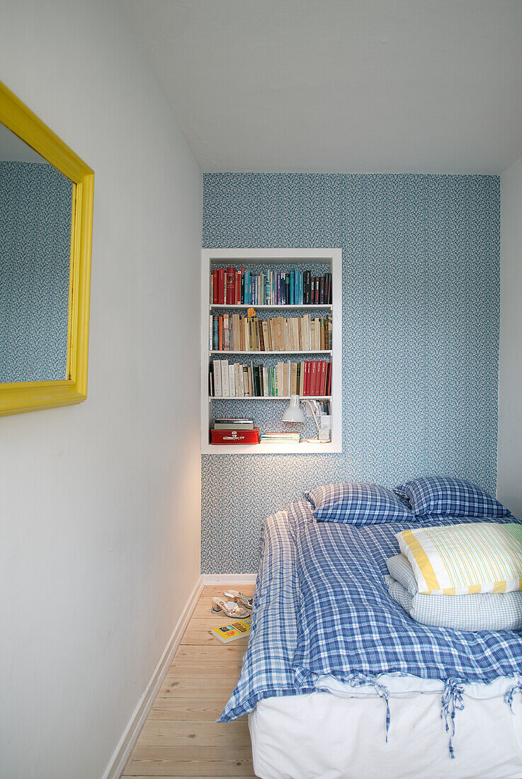 Blue wallpaper and shelving module in bedroom