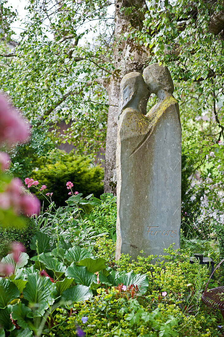 Cast stone statue of living couple in garden