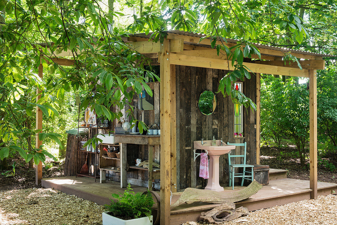 Outdoor kitchen and bathroom on façade of small wooden shed