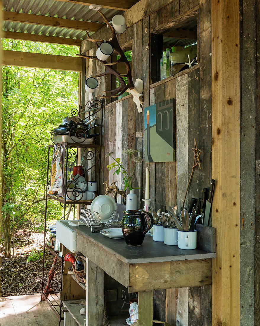 Outdoor-Küche an der überdachten Fassade einer kleinen Holzhütte