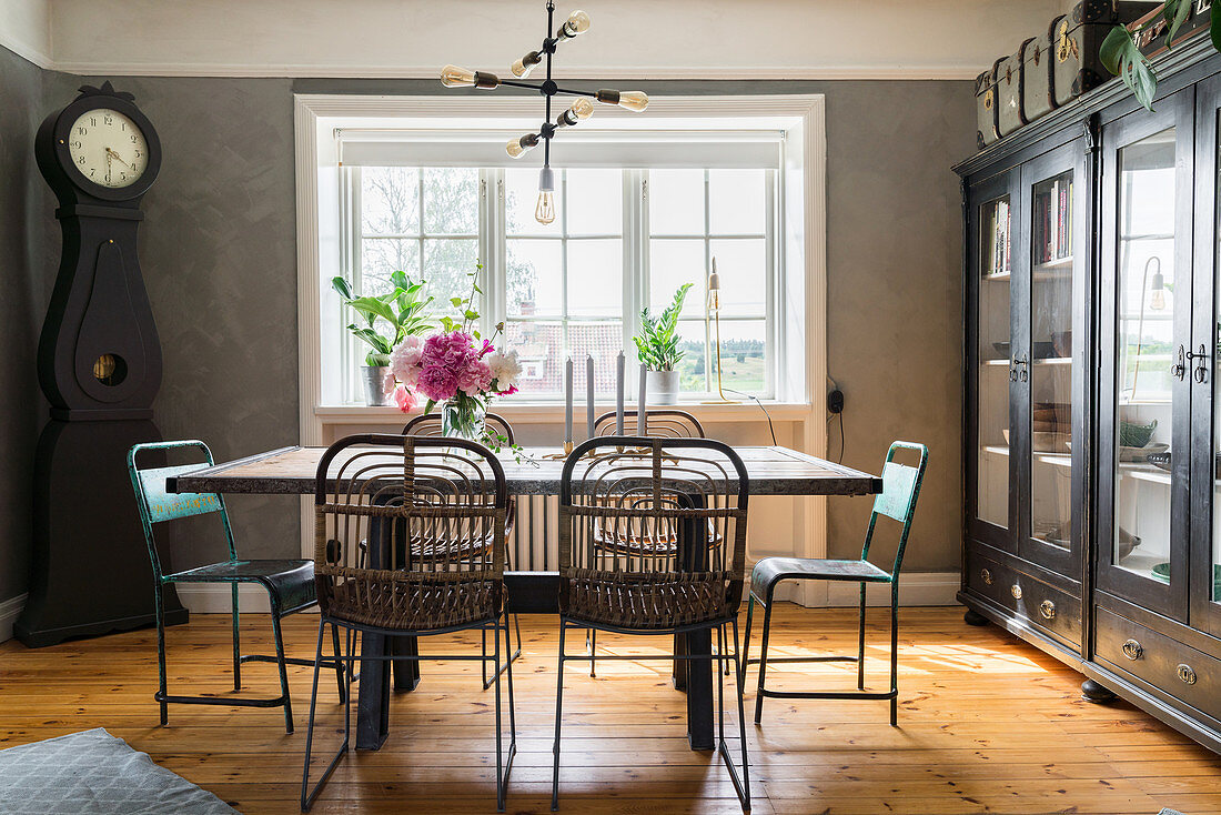 Dining table and vintage chairs on wooden floor and in front of window