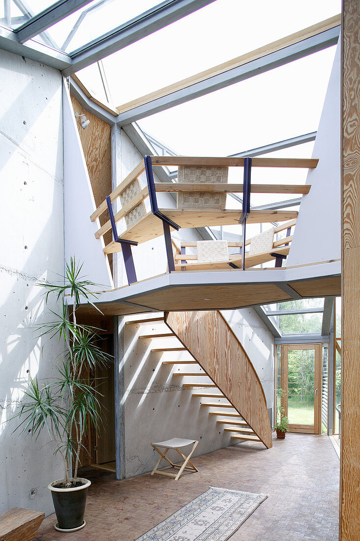 Offener Wohnraum mit Holztreppe im Architektenhaus