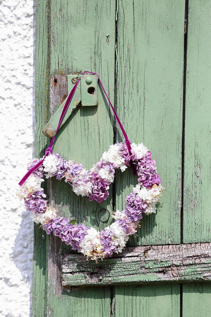 Heart-shaped wreath of lilac hung from door