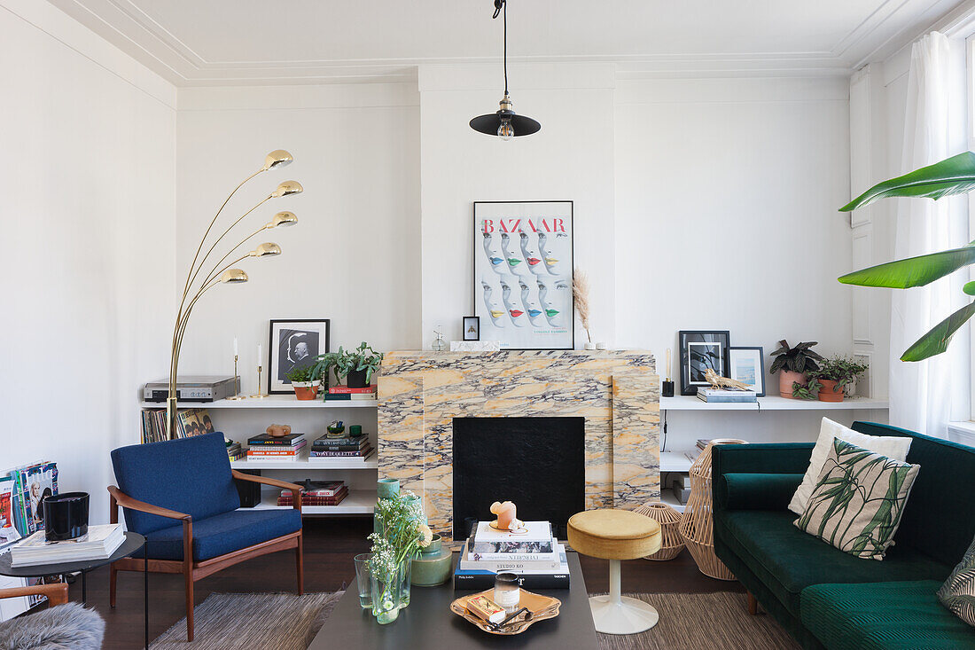 Living room with marble fireplace, blue armchair and dark green sofa