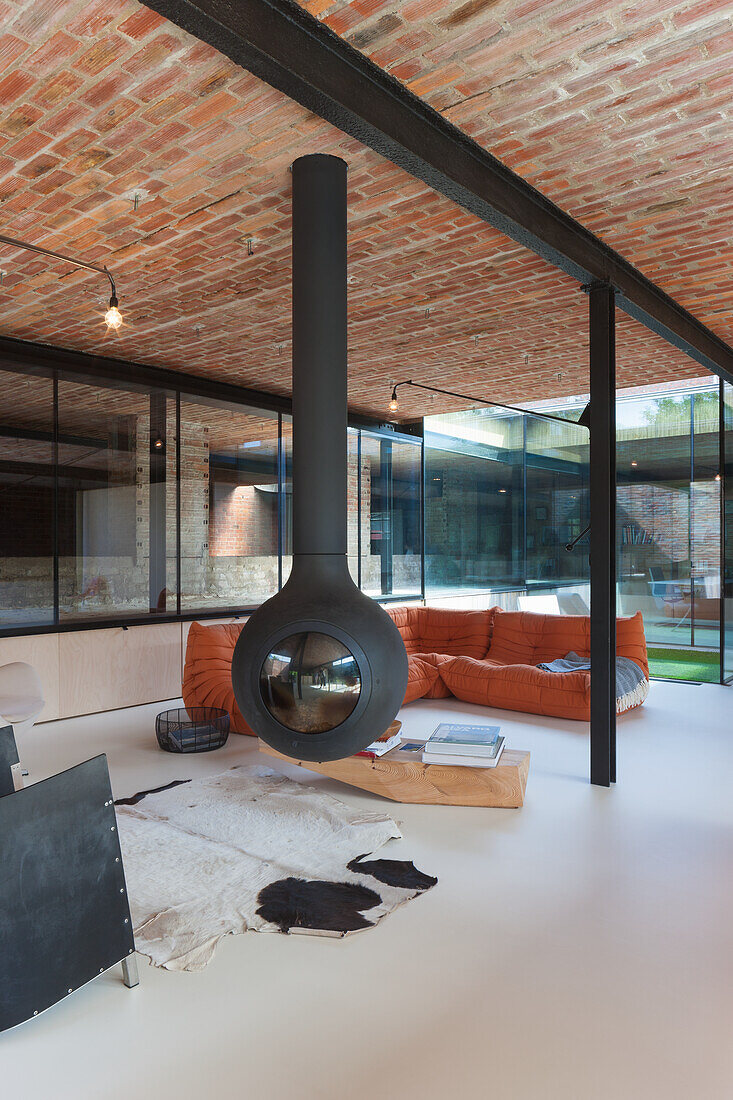 Living room with suspended fireplace, brick ceiling and orange sofa