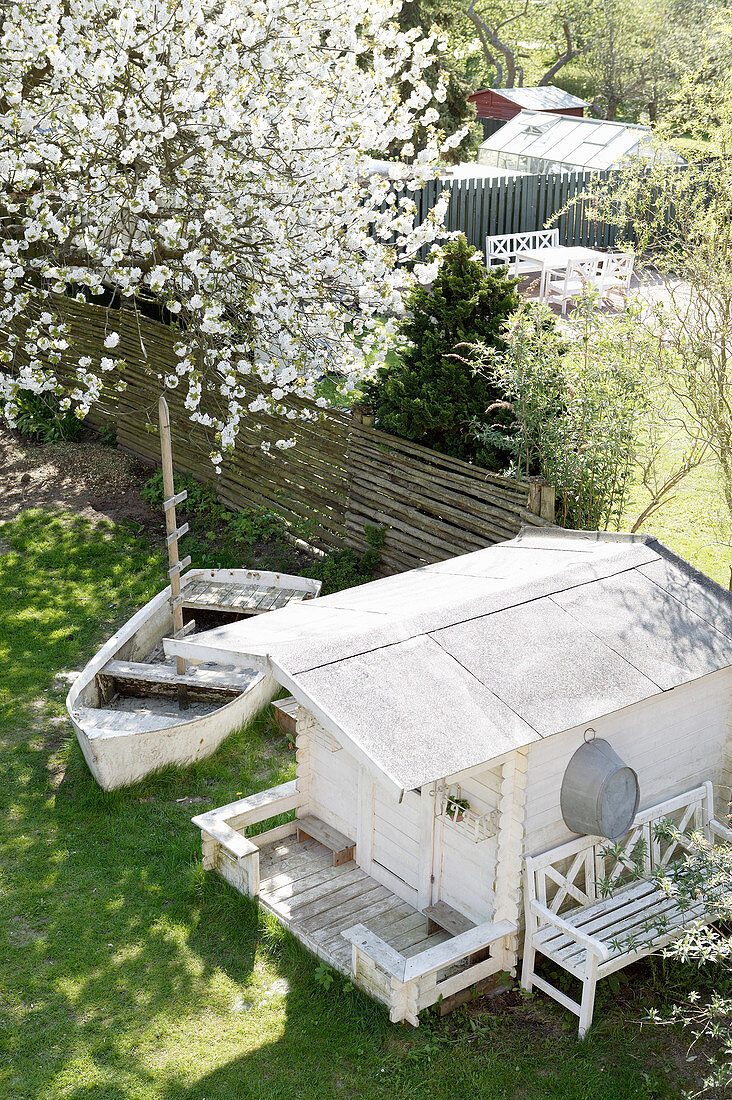 Blick von oben in den Garten mit Gartenhaus und altem Boot
