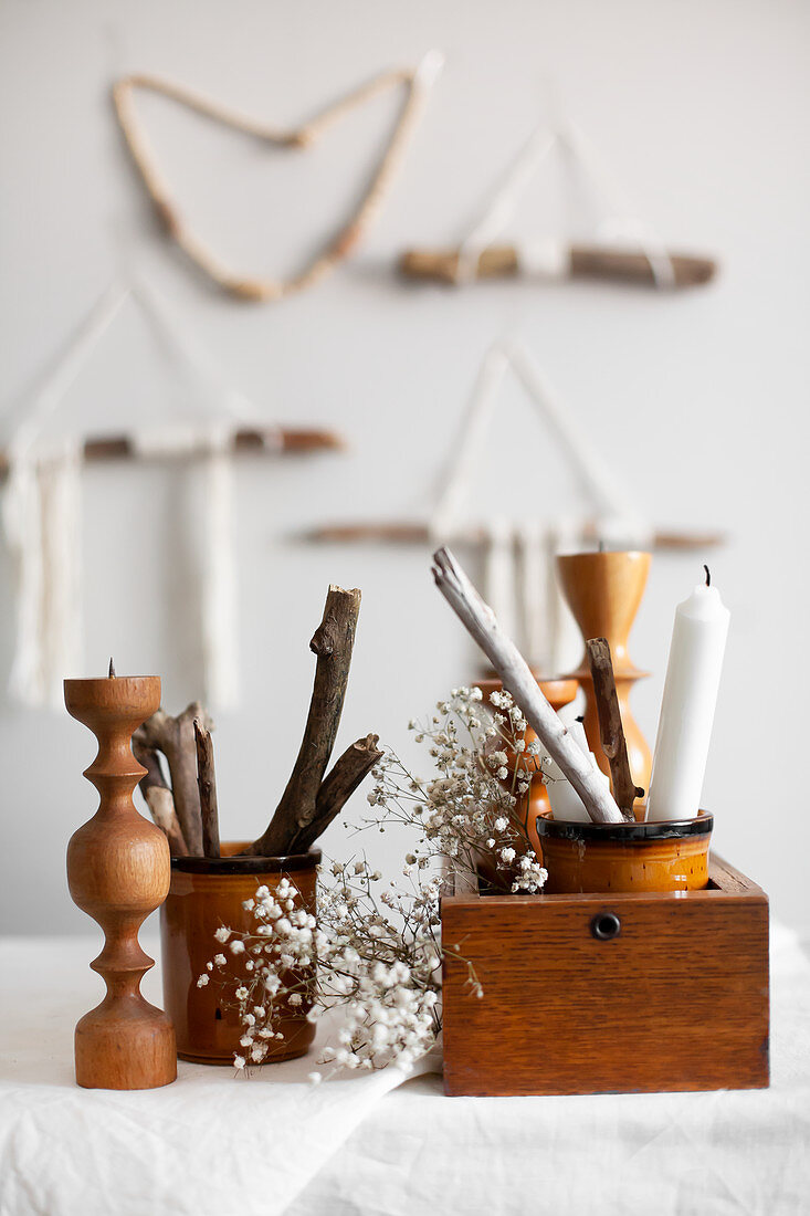 Natural, Bohemian-style arrangement of sticks, wool, candles and candle holders