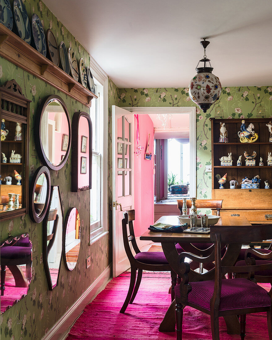 Deep pink rug and green floral wallpaper in classic dining room