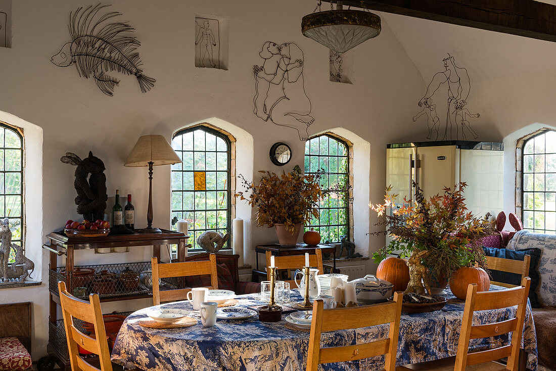 Gedeckter Tisch im künstlerischen Wohnraum mit Sprossenfenstern