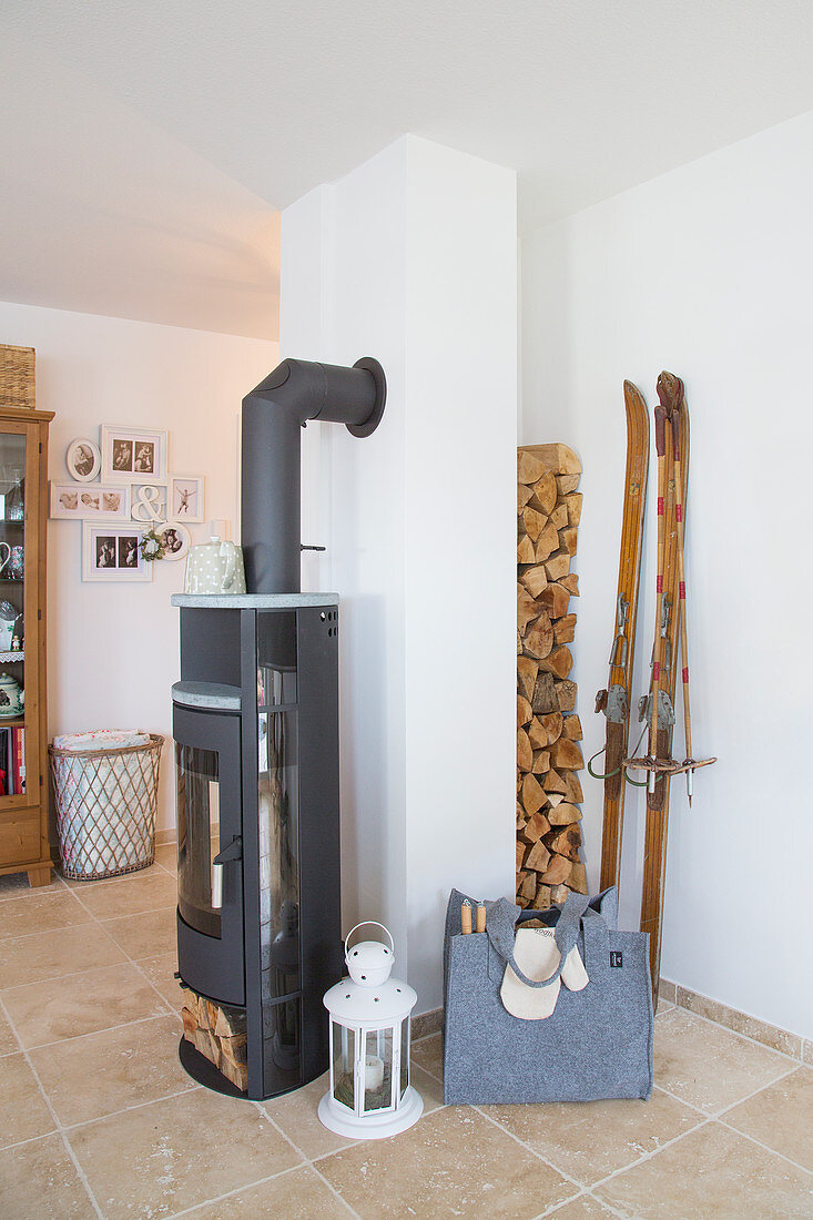 Firewood stacked in niche behind wood-burning stove in living room
