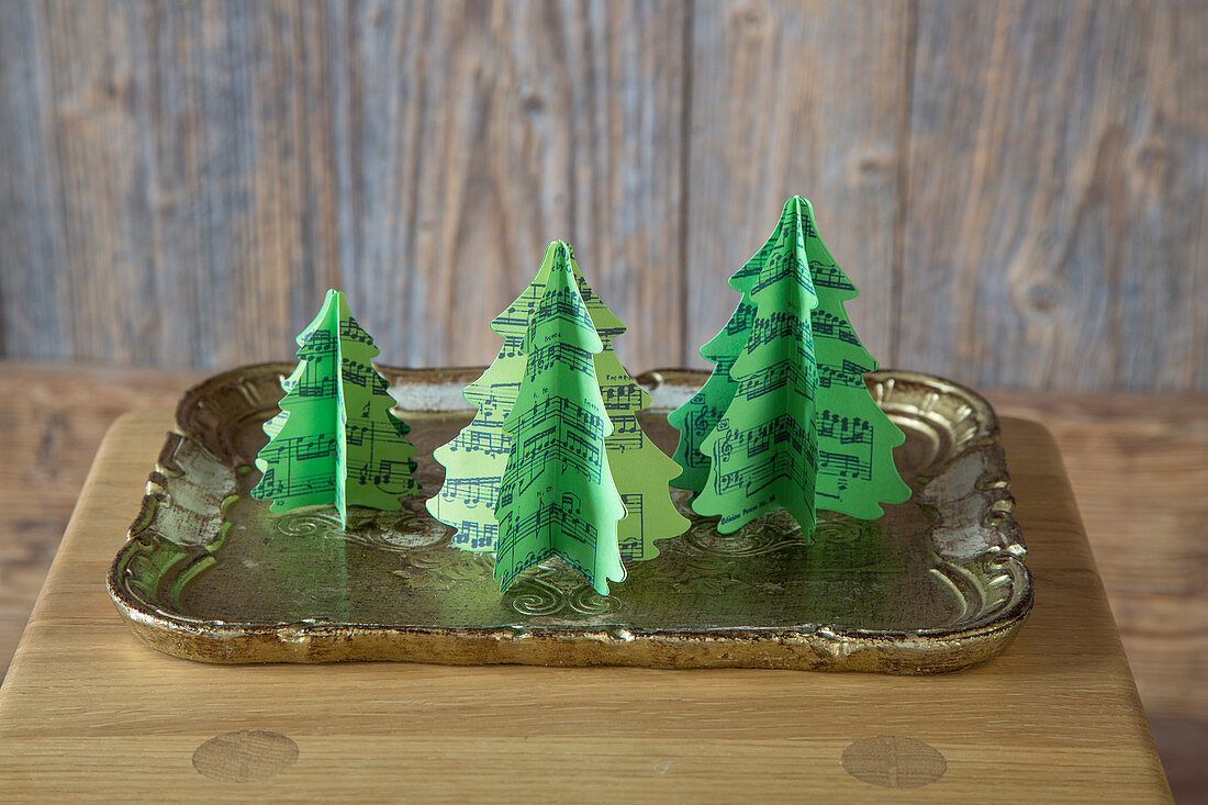 Festive arrangement of handmade paper Christmas trees made from sheet music