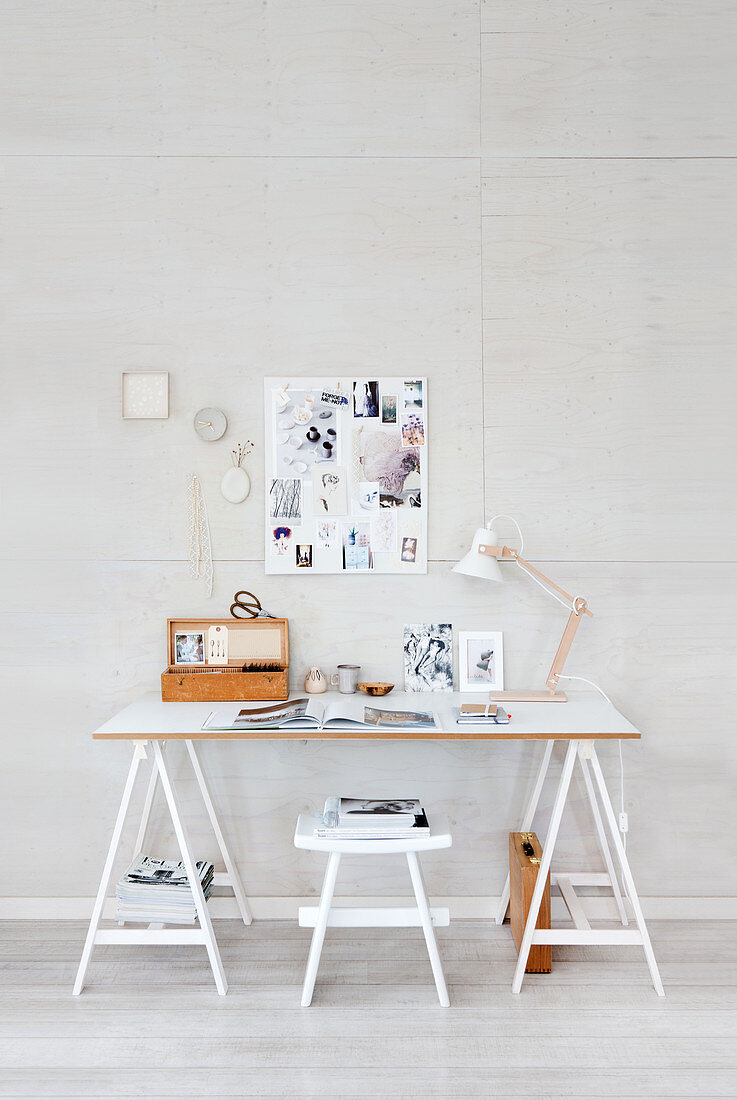 Desk on trestles and pinboard in study decorated in white