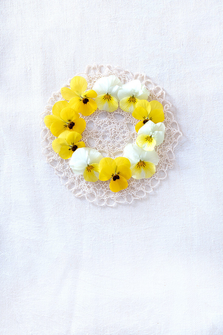 Wreath of violas laid on lace doily