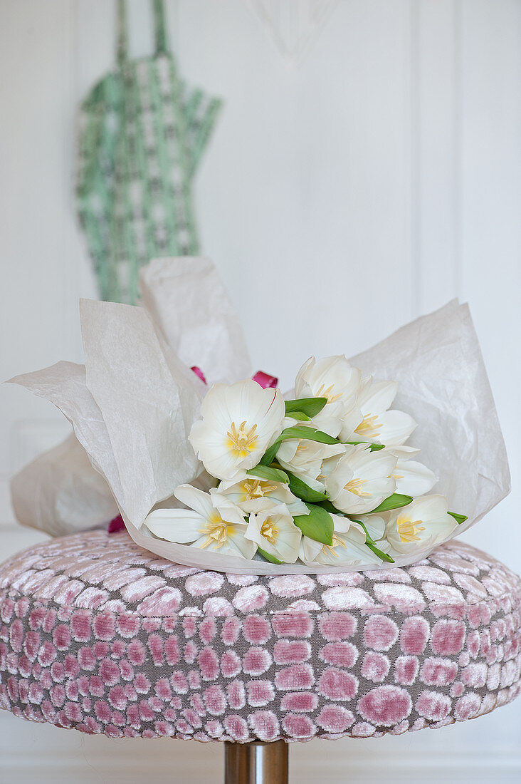Bouquet of white tulips on stool with velvet cover