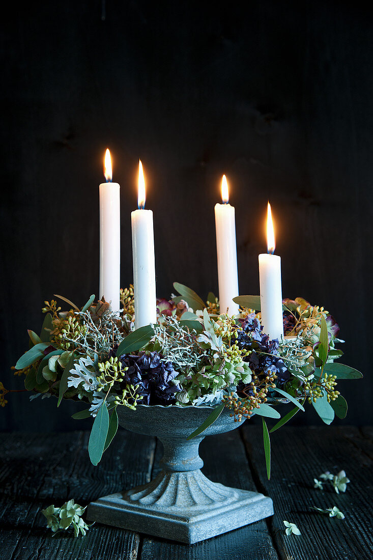 Advent wreath with hydrangea flowers and four candles in flower urn