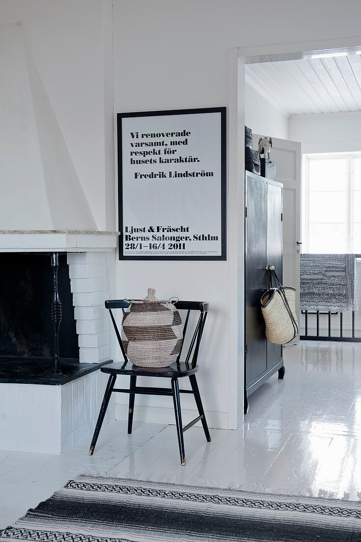 Raffia basket on chair below framed poster in Scandinavian house