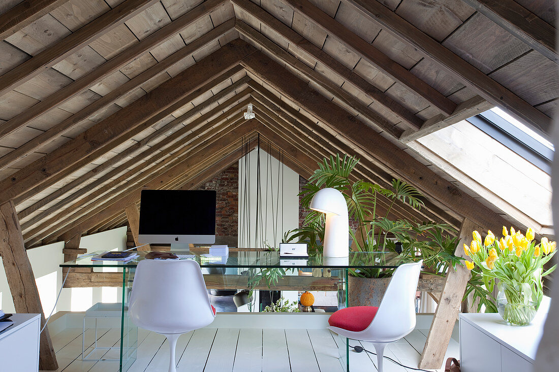 Schreibtisch aus Glas mit Designerstühlen unter dem Dach