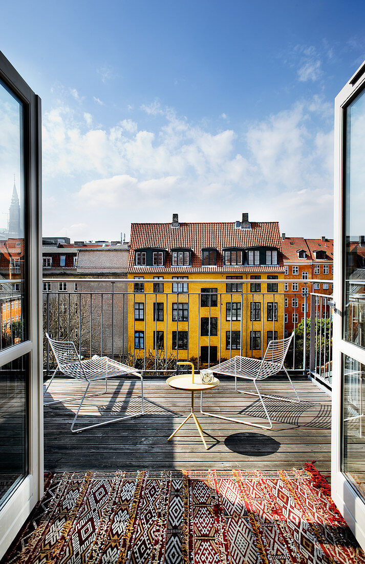 Metallmöbel auf sonniger Dachterrasse mit bunten Nachbarhäusern