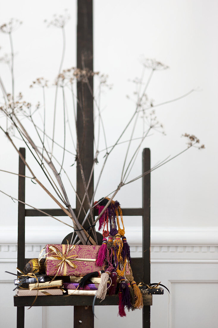 Verpackte Geschenke, Ethno-Deko und getrocknete Blumen auf Staffelei