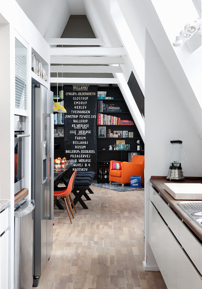 Blick aus Küche ins Esszimmer mit schwarzer Wand in Dachwohnung