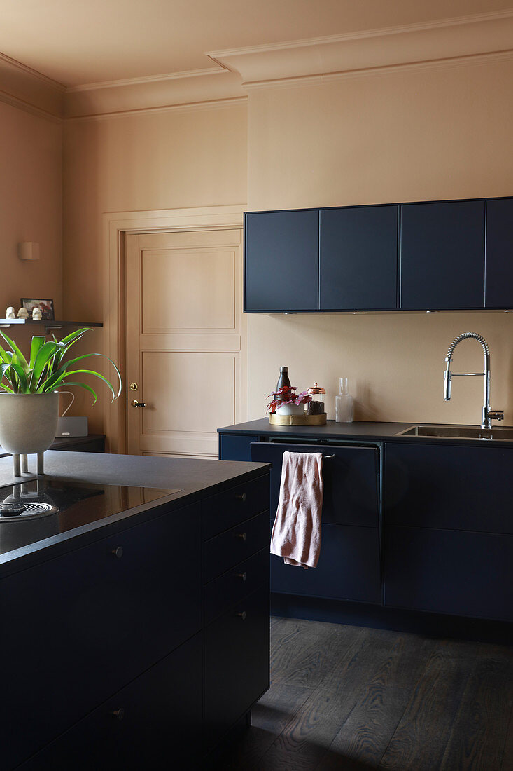 Moderne dunkelblaue Küche mit dunklem Boden und Wand in Beige