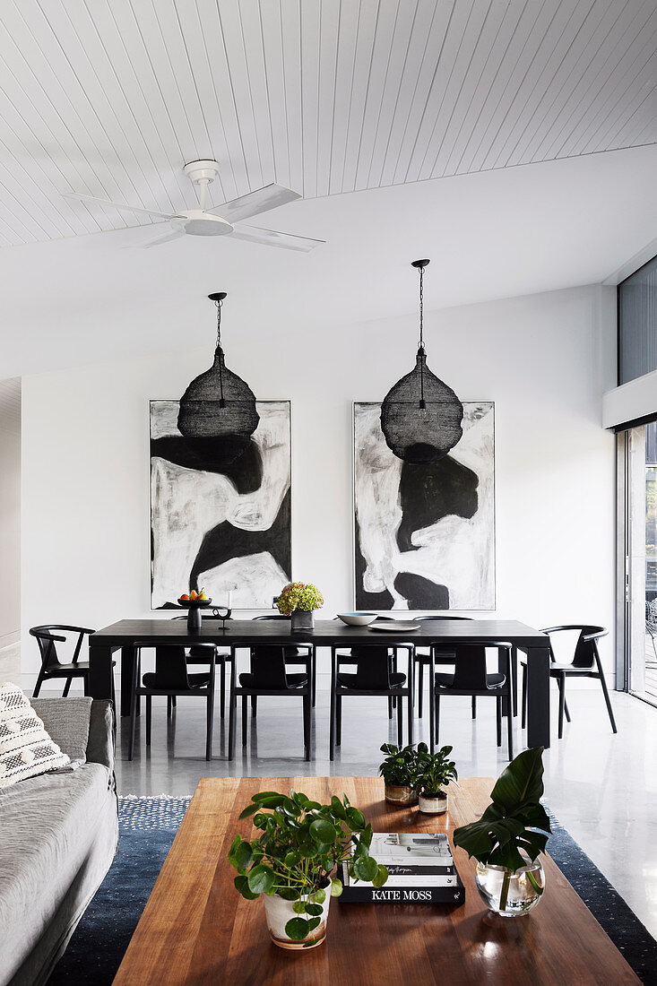 Table and chairs in black in the open living room with high ceiling