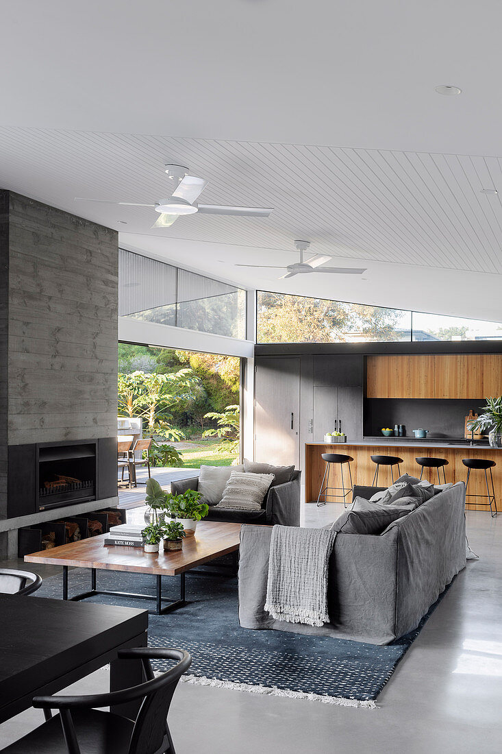 Modern open-plan living room in grey with open kitchen and garden access
