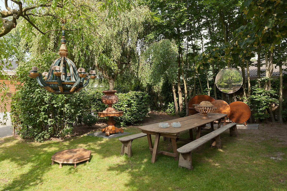 Tisch und Bänke im Garten mit künstlerischer Dekoration