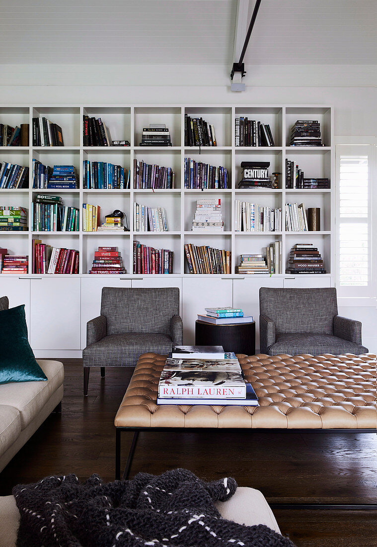 Colourful books in the living room with upholstered coffee table