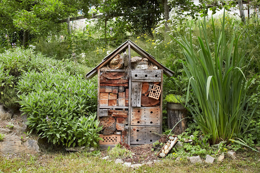 Handmade wooden insect hotel in natural-style garden
