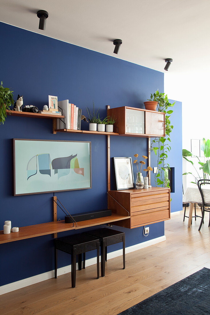 Wall combination in mid-century style on blue wall of living room