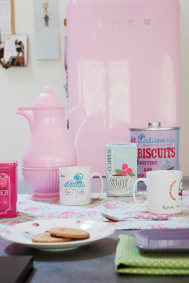 Table set in feminine style with pink coffee pot and kitschy accessories