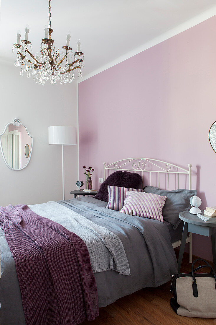Double bed against pink bedroom wall