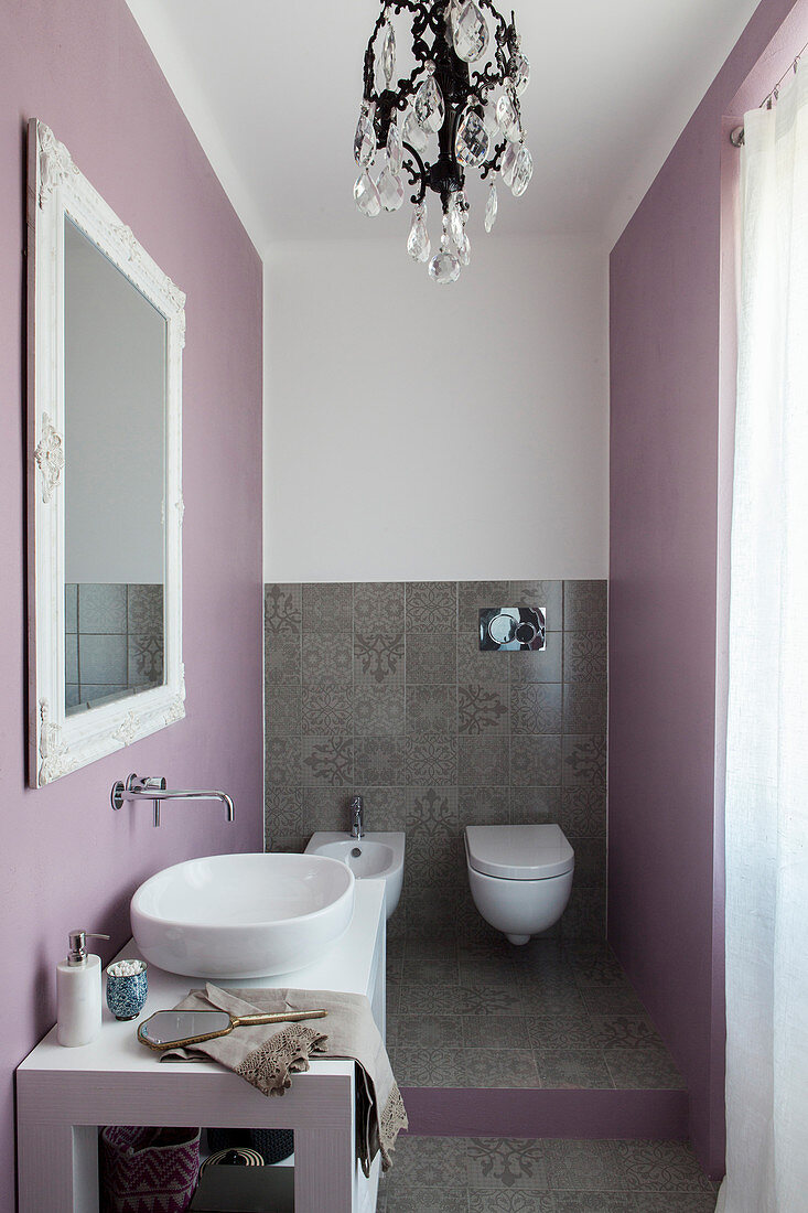 Elegantes Badezimmer mit Toilettenbereich, Bodenfliesen und Wand in Pastelllila