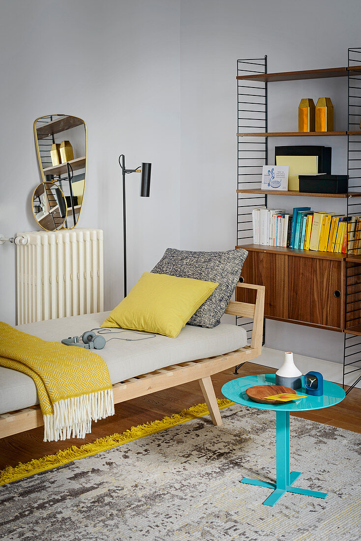 Tagesbett im Wohnzimmer mit Strinregal und gelben Farbakzenten