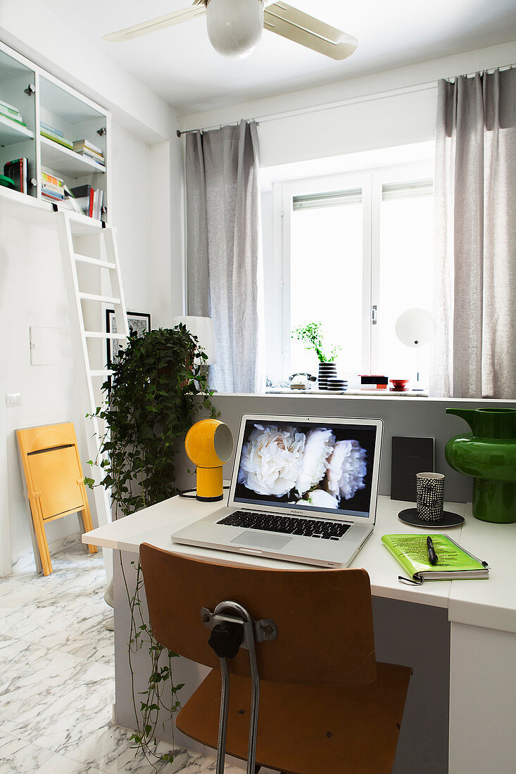 Home Office mit Klapptisch im Einzimmer-Apartment hinter Raumteiler