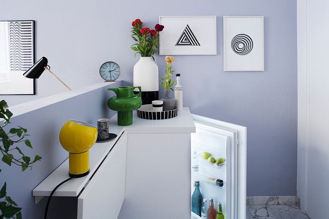 Multifunktionale Theke mit klappbarem Tisch hinter Raumteiler im Einzimmer-Apartment, Blick auf Kühlschrank