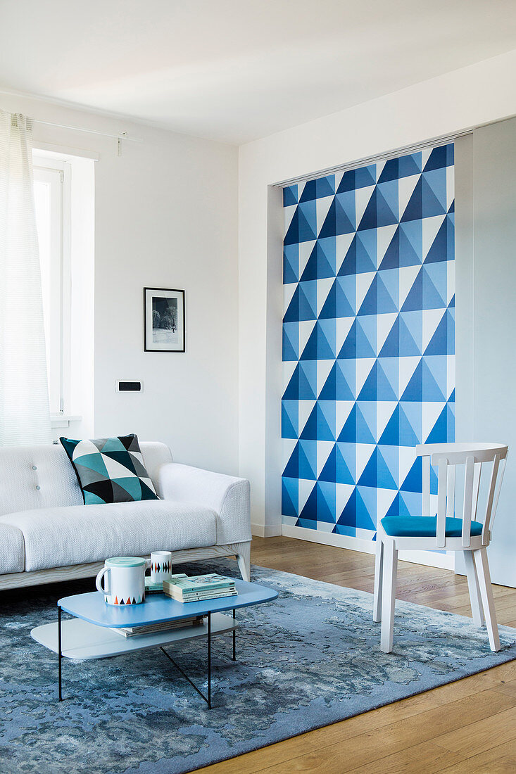 Dekoratives blau-weißes geometrisches Muster hinter Schiebewand im Wohnbereich