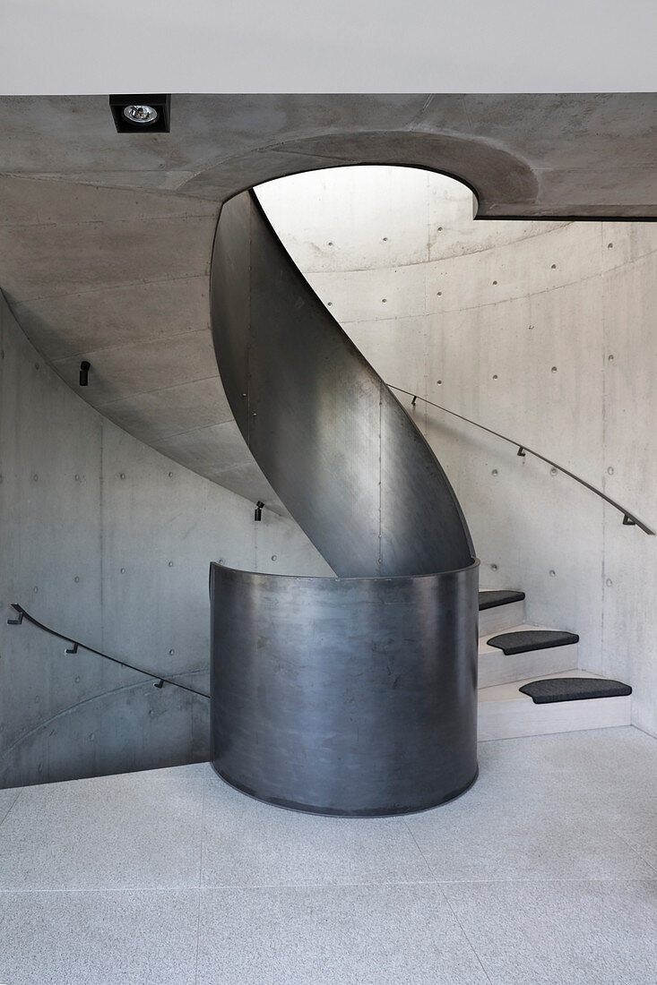 Concrete winding staircase with curving metal balustrade