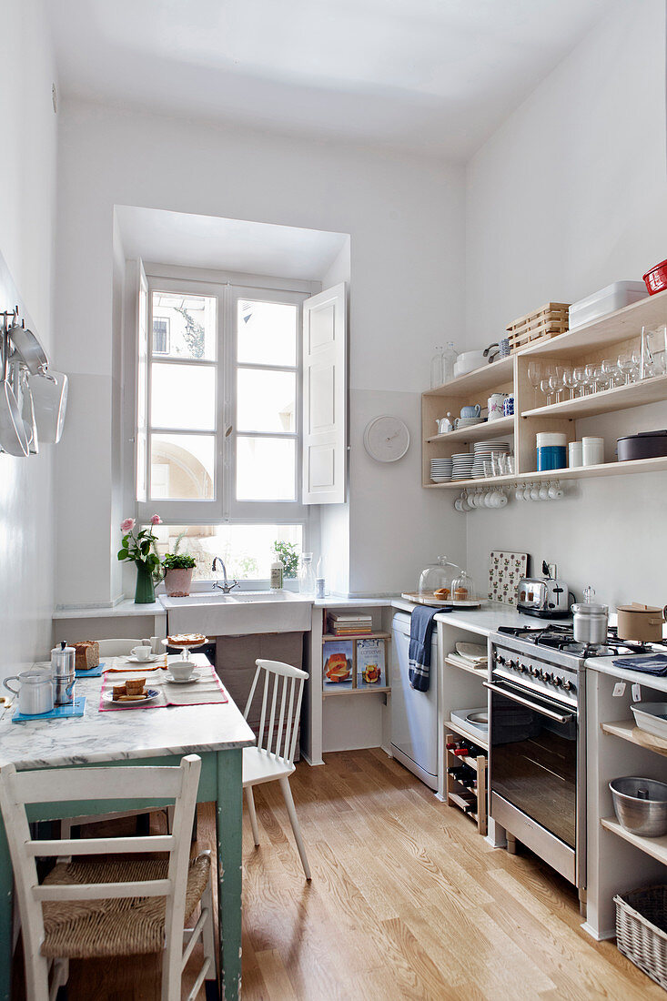 Helle Küche im Retrostil mit weißen Wänden und kleinem Esstisch