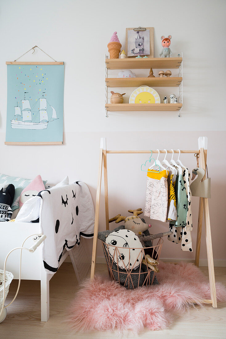 Clothes rail in contemporary child's bedroom in pastel shades