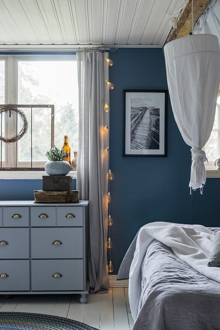 Schlafzimmer in Blau- und Grautönen mit Apothekerkommode