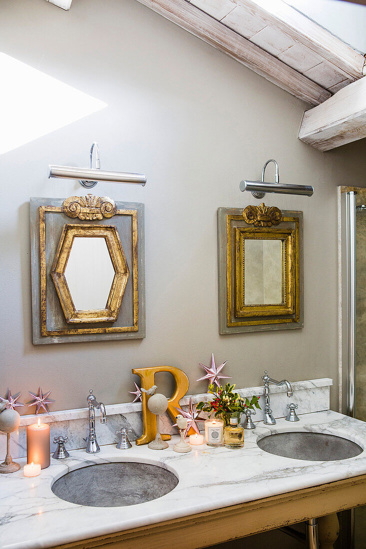 Marble washstand and gilt-framed mirrors in festively decorated bathroom