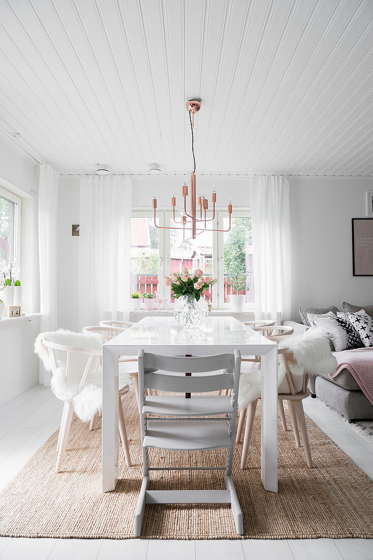 Grey high chair at dining table in bright, open-plan interior