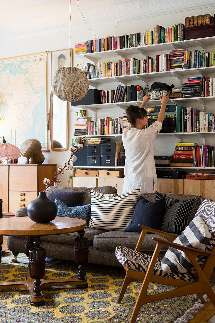 Woman in front of bookcase in eclectic, vintage-style living room