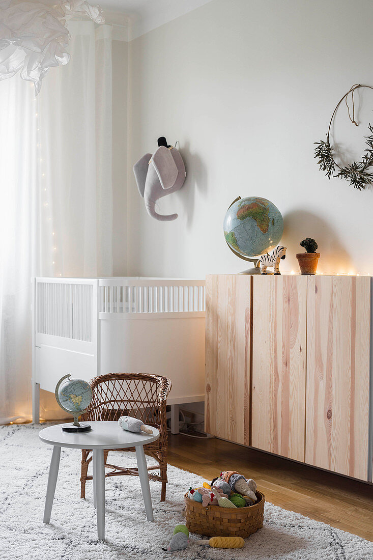 Floating wooden cabinet and cot in simple nursery